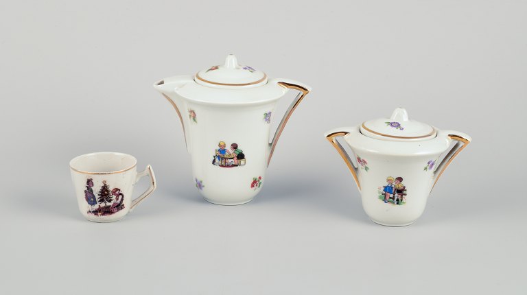 French dolls dinnerware/childrens tea set in porcelain. Coffee pot and sugar bowl along with one cup. Gold rim. Motifs of children.