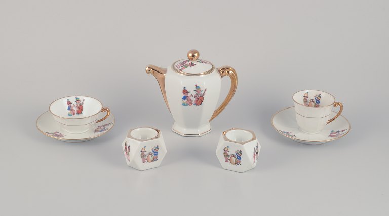 Limoges Porcelaine, France.Coffee pot, teacup, and a coffee cup with saucers, as well as two egg cups in porcelain. Motifs of child musicians.