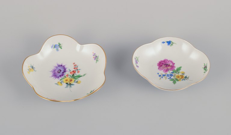 Meissen, Germany. Two porcelain bowls hand-painted with polychrome flowers. Gold rim.