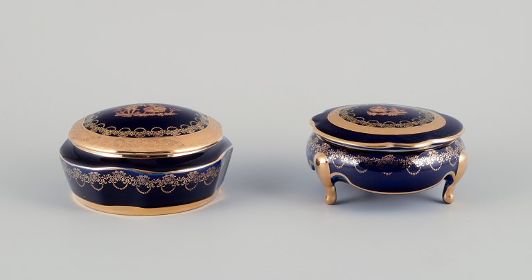 Limoges, France. Two lidded porcelain jars decorated with 22-karat gold leaf and featuring a beautiful royal blue glaze with a Scène galante.