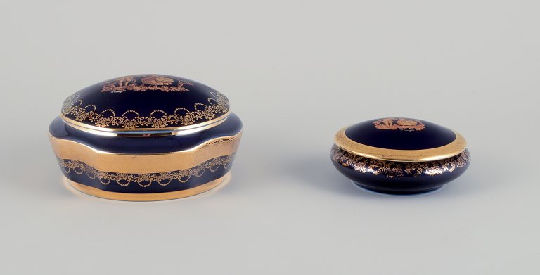 Limoges, France. Two lidded porcelain jars decorated with 22-karat gold leaf and a beautiful royal blue glaze. Scène galante.