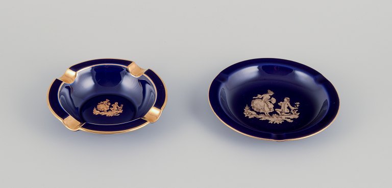 Limoges, France. Two small porcelain bowls decorated with 22-karat gold leaf and a beautiful royal blue glaze. Scène galante.
