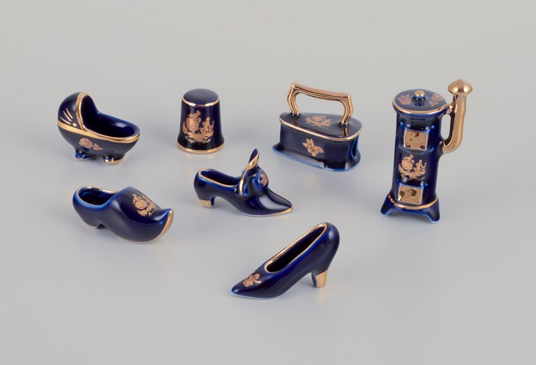 Limoges, France. Seven pieces of porcelain miniatures, decorated with 22-karat gold leaf and a beautiful royal blue glaze. Scène galante.