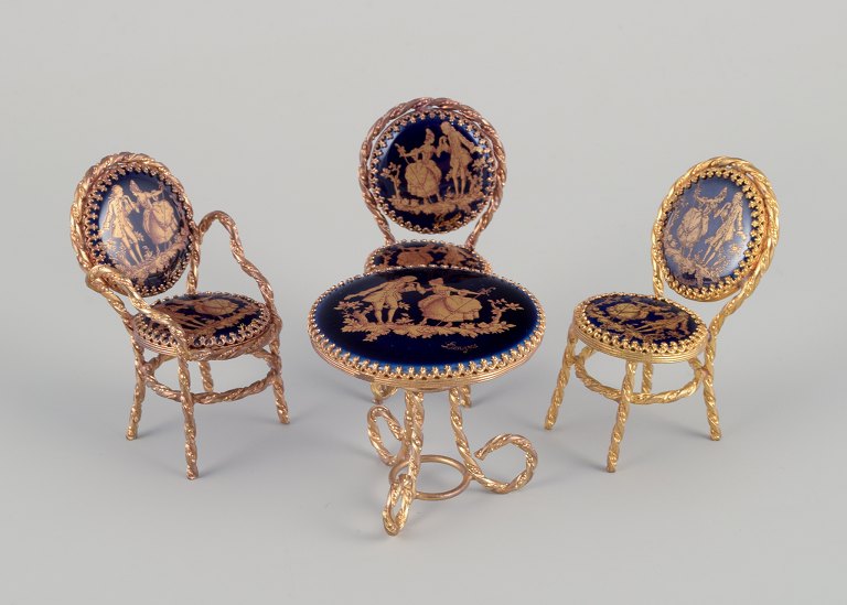 Limoges, France. Miniature table and chairs made of metal and porcelain, decorated with 22-karat gold leaf and a beautiful royal blue glaze. Scène galante.