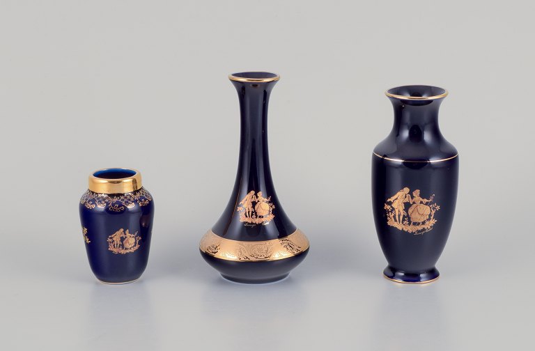 Limoges, France. Three small porcelain vases decorated with 22-karat gold leaf and a beautiful royal blue glaze. Scène galante.