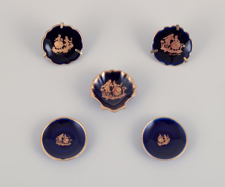 Limoges, France. Five small pieces of porcelain decorated with 22-karat gold leaf. Beautiful royal blue glaze. Scène galante.