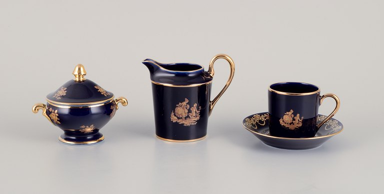 Limoges, France. Coffee cup, sugar bowl, and creamer in porcelain decorated with 22-karat gold leaf and beautiful royal blue glaze. Scène galante.