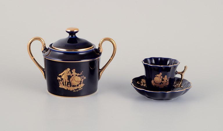 Limoges, France. Two pieces of porcelain consisting of a coffee cup and sugar bowl decorated with 22-karat gold leaf and beautiful royal blue glaze.