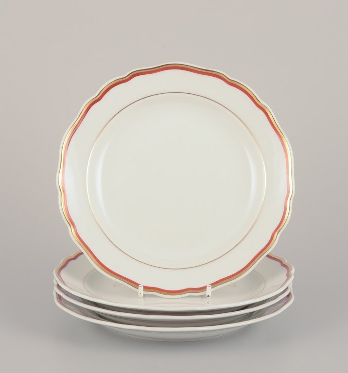 Meissen, Germany. A set of four plates. Decorated with coral red and gold-colored trim. Art Deco.