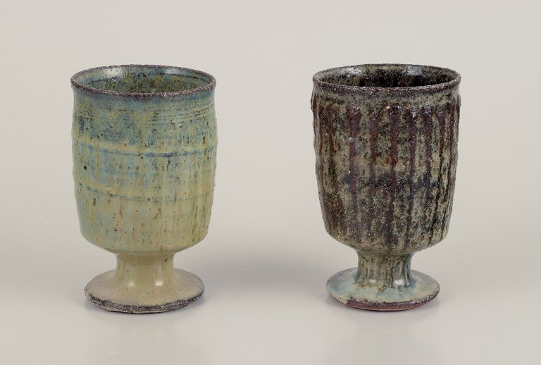 Gutte Eriksen, Denmark.Two cups in ceramic, raku technique, flowing lava glaze in brown tones.