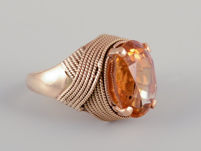 Swedish goldsmith. Large 18 karat cocktail ring adorned with faceted 
amber-colored citrin.