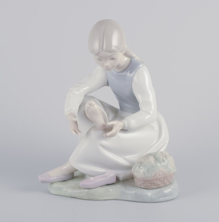 NAO, Spanien.
Porcelænsfigur af pige som holder hvil.