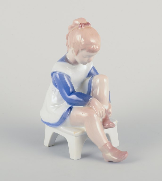 Bing og Grøndahl porcelænsfigur, siddende pige binder snørebånd.