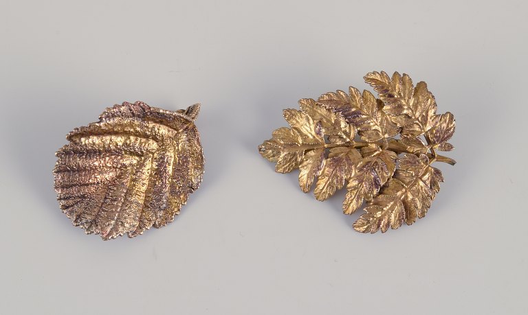 Flora Danica Jewellery, produceret hos Eggert. 
To brocher i form af blade forgyldt i sterlingsølv.