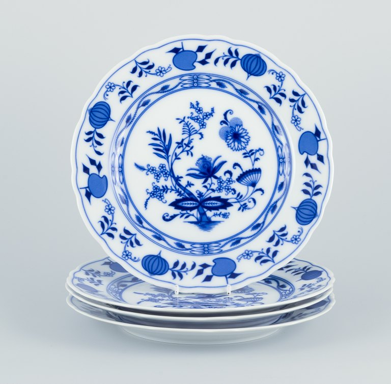A set of four dinner plates in porcelain with Blue Onion-patterned decoration.