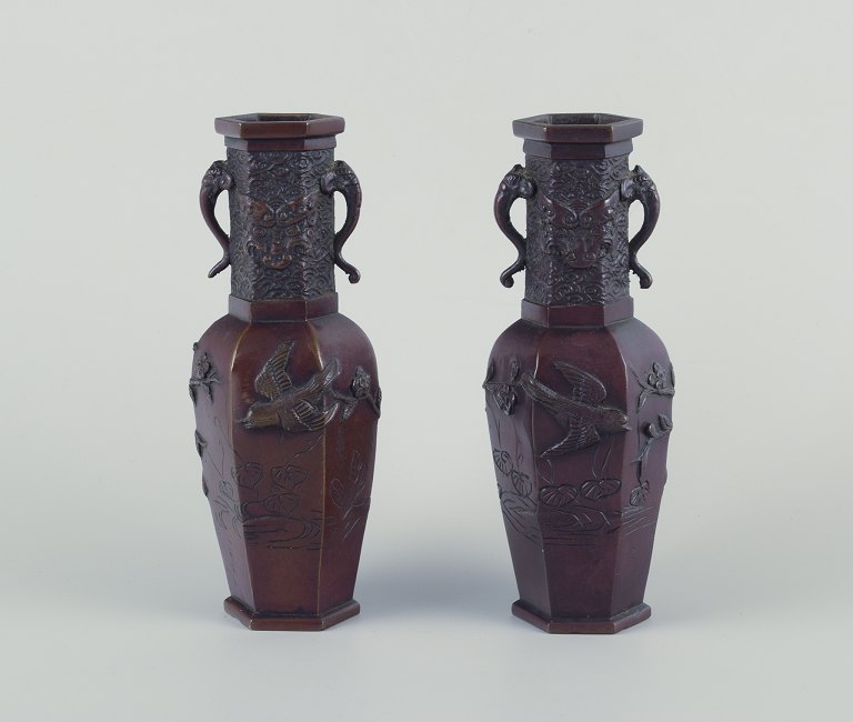 Japan, a pair of bronze vases from the Meiji period.Birds on branches in relief. Adorned with elephant heads.