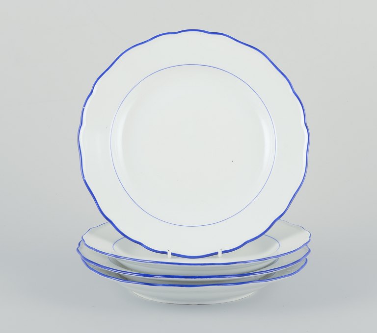 Meissen, Tyskland. Et sæt på fire middagstallerkener.Hvidt porcelæn med blå kant.
